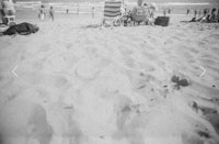 a black and white photo of people on a beach